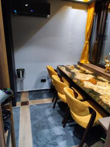斯科普里Smart Luxury Penthouse Suites - Private Sauna, Hot-Tub, Home Cinema at the best Location in Skopje的一间会议室,配有桌子和黄色椅子