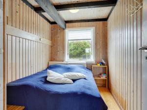 约灵Holiday Home Stella - 700m from the sea in NW Jutland by Interhome的一间卧室配有一张蓝色的床和窗户