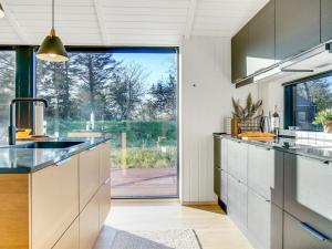 约灵Holiday Home Remko - 1-5km from the sea in NW Jutland by Interhome的一个带水槽和大窗户的厨房