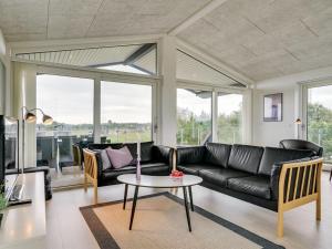腓特烈港Holiday Home Anabel - 500m from the sea in NE Jutland by Interhome的客厅配有黑色沙发和桌子