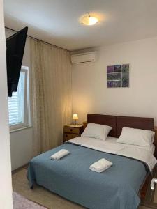 杜布罗夫尼克Dubrovnik Rooms 2的一间卧室配有一张床,上面有两条毛巾