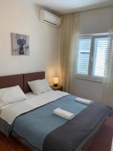 杜布罗夫尼克Dubrovnik Rooms 2的一间卧室配有一张床,上面有两条毛巾
