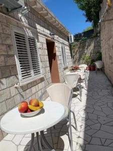 杜布罗夫尼克Dubrovnik Rooms 2的庭院内摆放着带水果的桌椅