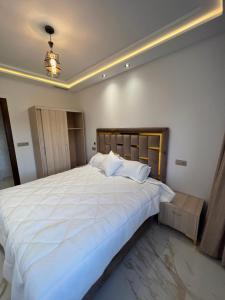 纳祖尔1 apartment de luxe hay almatar的一间卧室配有一张带白色床单的大床
