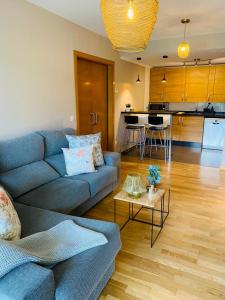 利亚内斯Apartamento Aldeana的一间带蓝色沙发的客厅和一间厨房