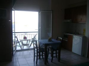 斯基亚索斯镇Skiathos city views studios-apartments的一个带桌椅的厨房和一个阳台