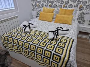 莱昂Casa Roman LUX的一间卧室配有一张带黄色枕头和鞋子的床。
