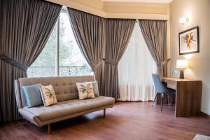 伊斯兰堡Hillside Residence E-7 by Paramount Hospitality的带沙发、书桌和窗户的客厅