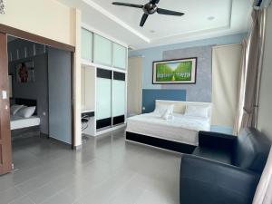 安顺MR Homestay HotelStyle Room Teluk Intan的一间卧室配有一张床、一张沙发和吊扇。