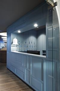 巴特哈尔巴达豪斯 - 酒店/餐饮/咖啡厅的厨房配有蓝色橱柜和白色柜台。