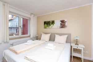 普劳西Hafendorf Haus 7_ Apartment 4的一间卧室设有两张床和窗户。