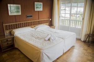 比韦罗阿斯阿雷亚斯二号酒店的一间卧室配有一张带白色床单的床和一扇窗户。