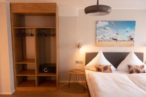 德赖艾希赫恩伯德与斯坦戴克酒店的一间卧室设有一张床和一个书架