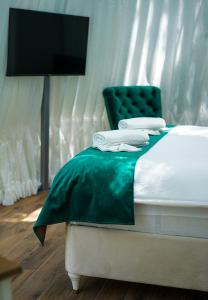 RačićTurističko naselje- Japodski otoci的一间卧室配有一张床和一把绿色椅子