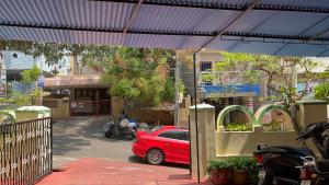 维沙卡帕特南The Padmavathi Guest House - Vizag的一辆红色的汽车停在蓝色的天篷下