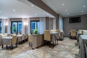 圣雷莫Hotel Globo Suite-Correnti hotels的一间在房间内配有桌椅的餐厅