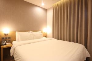 釜山Hotel Prima Busan的酒店客房设有一张白色大床和一个窗户。