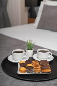 伊斯坦布尔Depiero Hotel Karaköy的两杯咖啡和一盘松饼和纸杯蛋糕