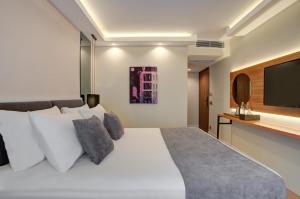 伊斯坦布尔Depiero Hotel Karaköy的卧室配有白色的床和平面电视。