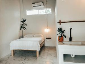 阿亚姆佩Ayampe Lofts的白色卧室设有床铺和水槽