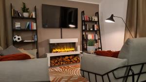 维尔道Penthouse in Villa am Wasser + Parken + WLAN + Netflix +Kamin的客厅设有壁炉和电视。