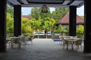 卢萨卡Palm Kalash Hotel的一个带桌椅的庭院和一个游泳池