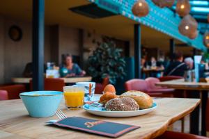海边的艾格蒙特德布依酒店的一张桌子,上面放着一盘糕点和橙汁