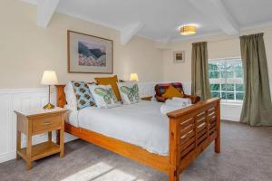 WhittingehameStylish country home near East Linton and Edinburgh的一间卧室设有一张大型木床和一个窗户。