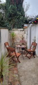 洛什Logement cosy centre Loches的庭院配有两把椅子、一张桌子和一张桌子