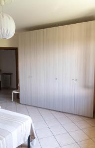 LuniAppartamento per Vacanze Domus Lunae的卧室配有白色橱柜和1张床。