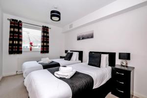 阿伯丁Orange Apartments - Kepplestone的一间卧室配有两张带白色床单的床