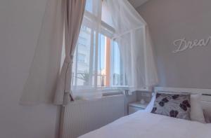 萨格勒布Main Square Dream Apartment的卧室配有白色的床和窗户。