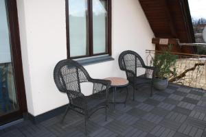 沃尔特湖畔韦尔登Haus Sonnental Velden am Wörthersee的庭院里设有三把藤椅和一张桌子