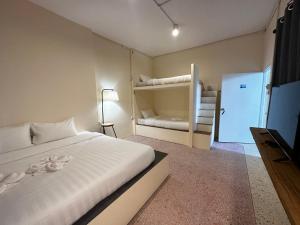 洛坤府Norm Space Hostel NST的一间卧室配有一张床和一张双层床。
