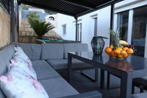 特罗吉尔Luxury Villa Lana Apt, Seaview Terrace, Large Outdoor Space, BBQ的客厅配有沙发和水果桌