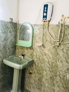 尼甘布Sun Rise Hostel的浴室设有水槽和墙上的镜子