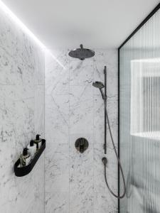 维也纳The Amauris Vienna - Relais & Châteaux的带淋浴的浴室和玻璃墙