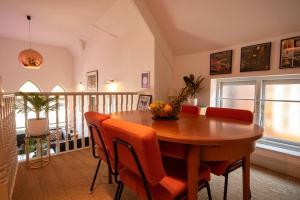 斯卡伯勒Church House Loft的配有木桌和橙色椅子的用餐室