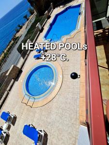 库拉海滩DELUXE 3 Rooms74m2,TRANSFE-R inc! SEAVIEW on AMADORES,2 heatPOOLs, PARKING, 600 MB,Dishwasher,2Lift,,3 BEACHes的海边庭院的游泳池