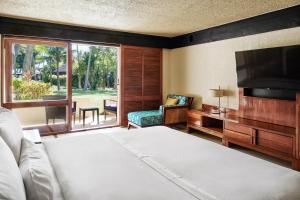 丹娜努斐济丹娜拉岛威斯汀spa度假酒店的一间卧室配有一张床、一台电视和一把椅子