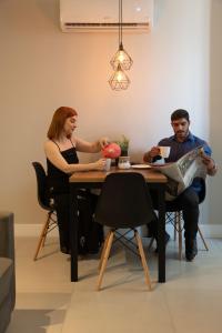 里约热内卢Art Inn Porto的坐在桌子上的男人和女人