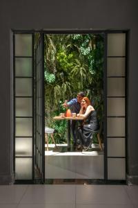 里约热内卢Art Inn Porto的坐在窗前桌子上的男人和女人