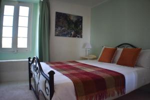 PuivertL'Occitania Chambre d'hotes的一间卧室配有一张带毯子的床和窗户