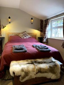 阿利士Charming, rustic & well equipped garden cottage的一间卧室配有带毛巾的床