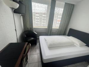 美因河畔霍海姆Hotel & Restaurant Main Taunus的小房间设有床、书桌和窗户