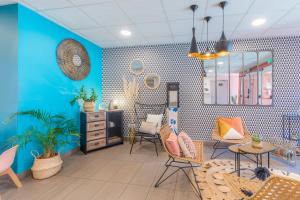 科尔讷巴里厄Appart'City Confort Toulouse Aéroport Cornebarrieu的一间拥有蓝色墙壁、椅子和镜子的客房