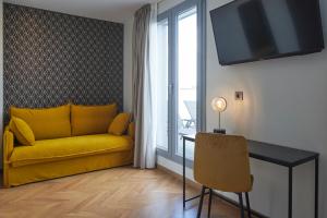 圣塞瓦斯蒂安HOTEL ARRIZUL CATEDRAL的客厅配有黄色的沙发和桌子