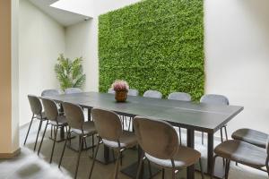 圣塞瓦斯蒂安HOTEL ARRIZUL CATEDRAL的一间会议室,配有桌椅和绿色的墙壁