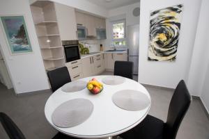 普罗马尼亚Luxury Apartment Luka的厨房配有白色桌子,上面放着一碗水果