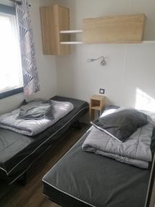 翁赞BVCO LOCATIONS PROCHE CHATEAUX ET BEAUVAL DANS LE LOIR et CHER的一间卧室设有两张床和窗户。